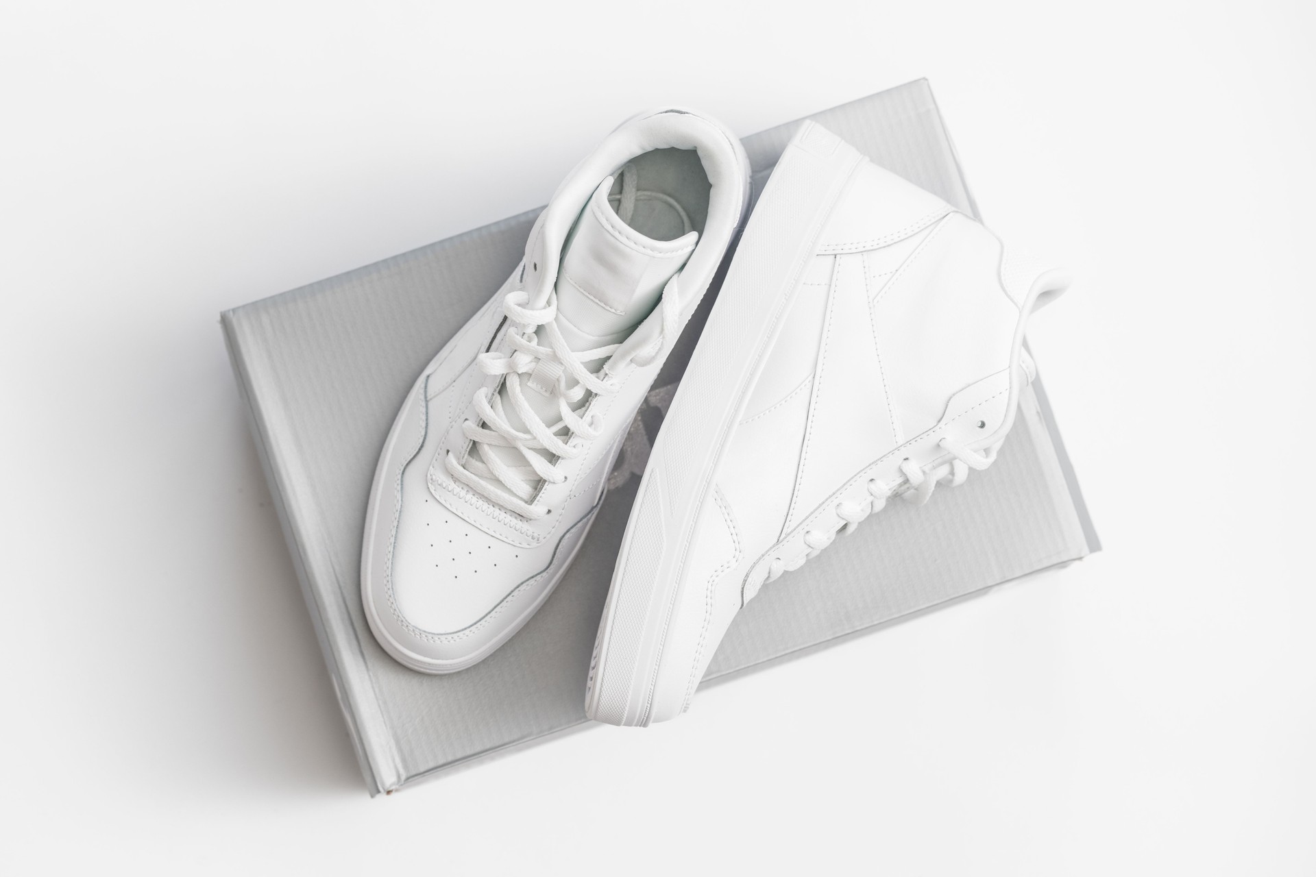 Vintage white sneakers on the shoebox isolated on white background